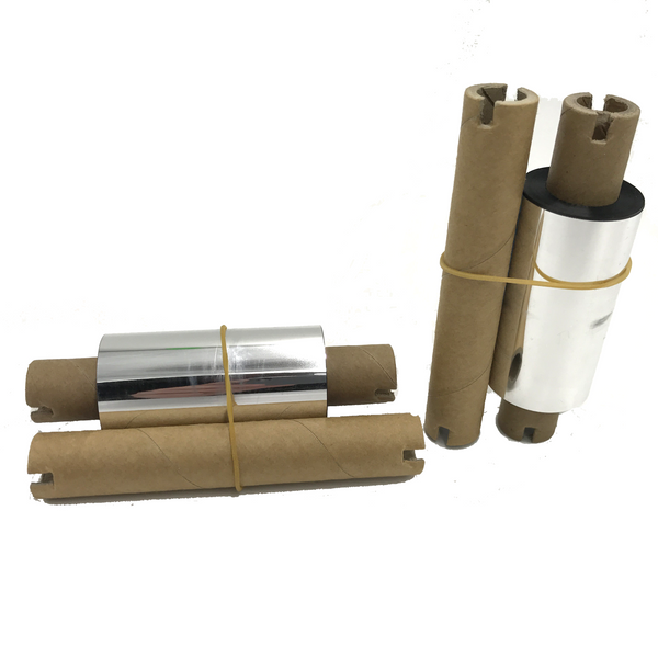 A set of three Zebra printer ribbons with metallic finish, wrapped in cardboard and secured with yellow bands.